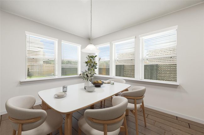Start your day off right with a cup of coffee sitting with your family in the lovely breakfast area! Featuring large windows with blinds, custom neutral paint, and wood style flooring, perfect for casual dining with a view of the backyard. *Virtually Staged | Image 12