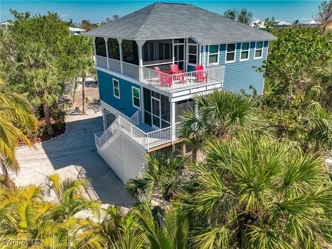 Back of property featuring driveway, a sunroom, a balcony, and roof with shingles | Image 48