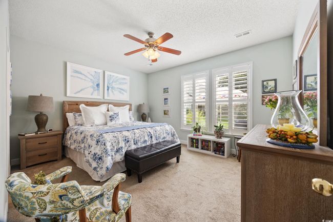 Bedroom featuring light colored carpet, a textured ceiling, and a ceiling fan | Image 16