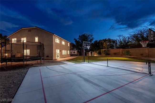 View of sport court with a yard, a trampoline, community basketball court, and fence | Image 53