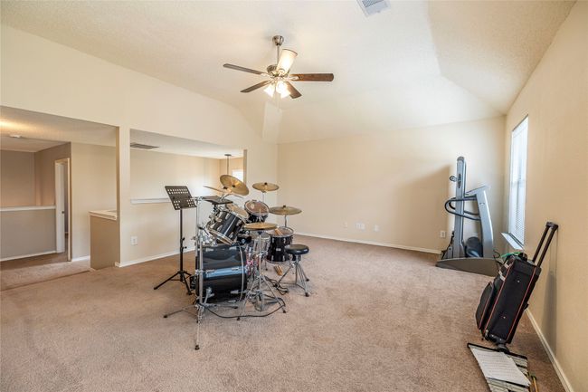Recreation room featuring lofted ceiling, carpet floors, ceiling fan, and baseboards | Image 27
