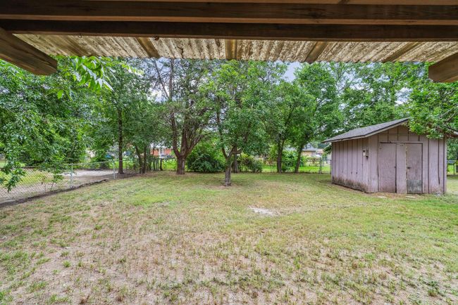 Fenced backyard with a storage shed | Image 26