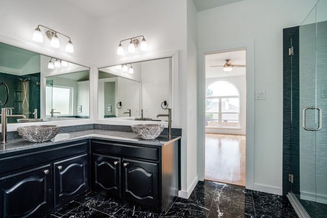Bathroom featuring marble finish flooring, double vanity, a stall shower, and baseboards | Image 32