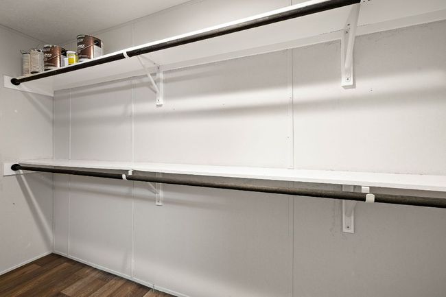 Walk in closet with dark wood finished floors | Image 27