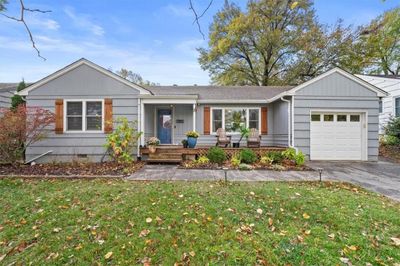 Ranch-style home featuring a garage, a front yard, and a porch | Image 1