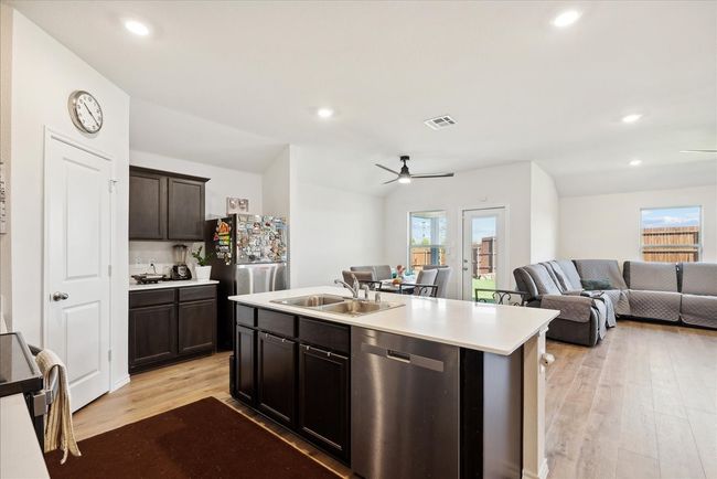 Kitchen featuring stainless steel dishwasher, a ceiling fan, healthy amount of natural light, light wood finished floors, and recessed lighting | Image 4