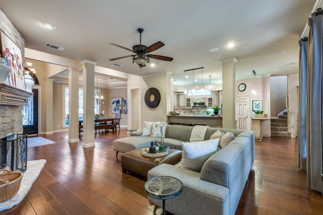 Living area featuring ornate columns, a ceiling fan, stairs, baseboards, and recessed lighting | Image 6