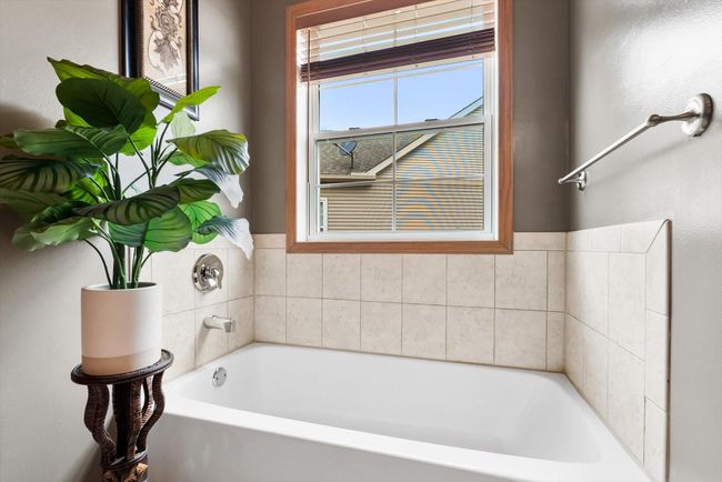 Relax and unwind in the soaking tub, perfectly positioned beneath a window for soft natural light. | Image 31