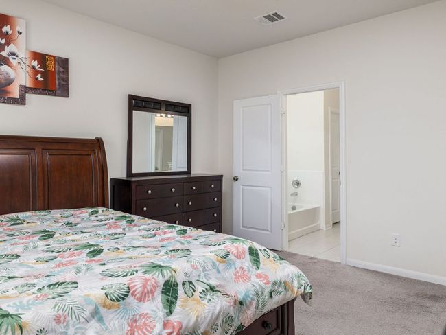 Bedroom with light colored carpet, baseboards, and ensuite bath | Image 12