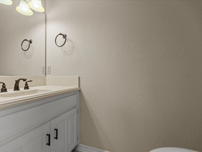 Half bathroom near utility room / garage featuring vanity and toilet | Image 19