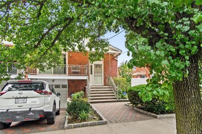 View of property hidden behind natural elements featuring a garage | Image 2