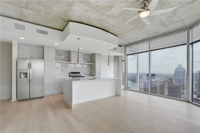 Kitchen with light countertops, tasteful backsplash, expansive windows, stainless steel appliances, and light wood finished floors | Image 10