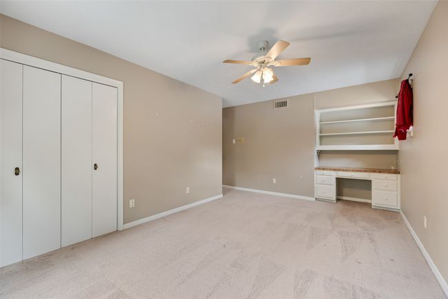 Unfurnished bedroom featuring light colored carpet, baseboards, a ceiling fan, and a closet | Image 16