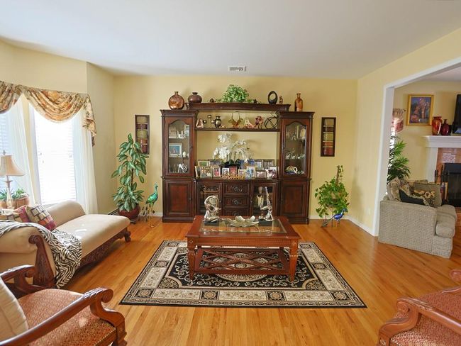 Living room with baseboards, visible vents, a tiled fireplace, and wood finished floors | Image 18