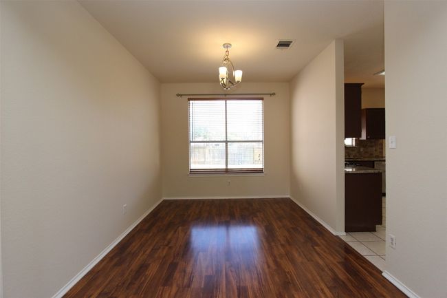 Unfurnished dining area featuring a chandelier and wood finished floors | Image 11