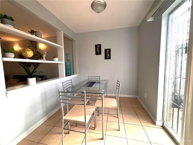 Tiled dining space with built in features and baseboards | Image 6