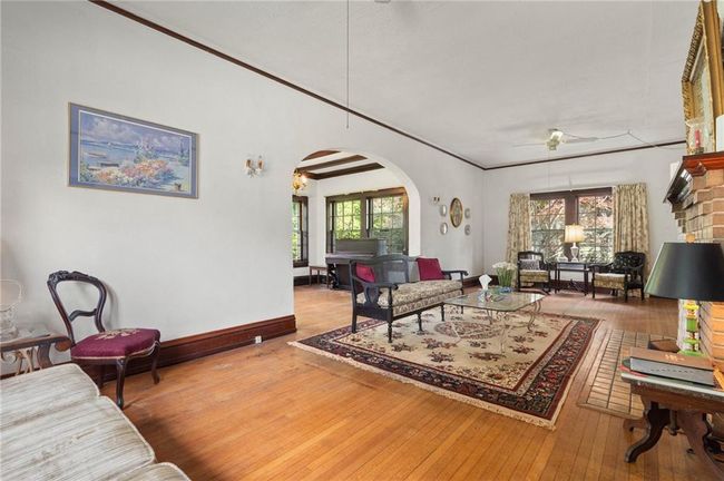 Large living room featuring hardwood flooring, arched walkways, and wide baseboards. | Image 6
