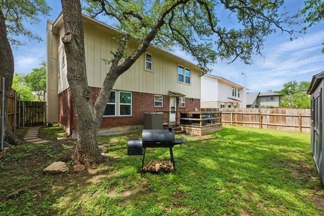 The beautifully landscaped backyard offers a private oasis with mature trees, magnolias, and vibrant flowers. | Image 29