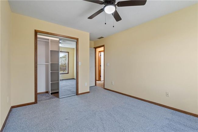Unfurnished bedroom with carpet flooring, baseboards, a ceiling fan, and visible vents | Image 11
