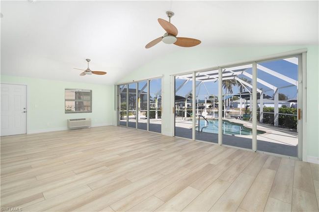 Unfurnished sunroom with a ceiling fan and an AC wall unit | Image 4
