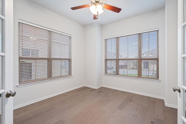 Spare room featuring baseboards, wood finished floors, and a ceiling fan | Image 4
