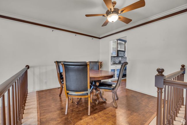 Dining room with crown molding, ceiling fan, wood finished floors, and baseboards | Image 8