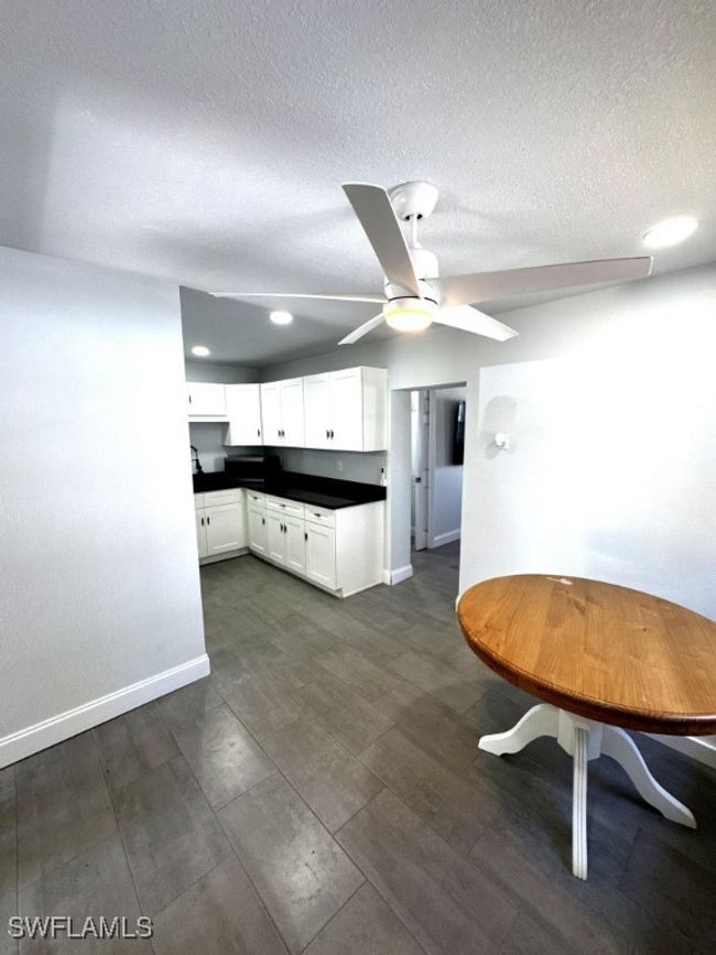 Kitchen featuring white cabinetry, dark countertops, baseboards, and ceiling fan | Image 10
