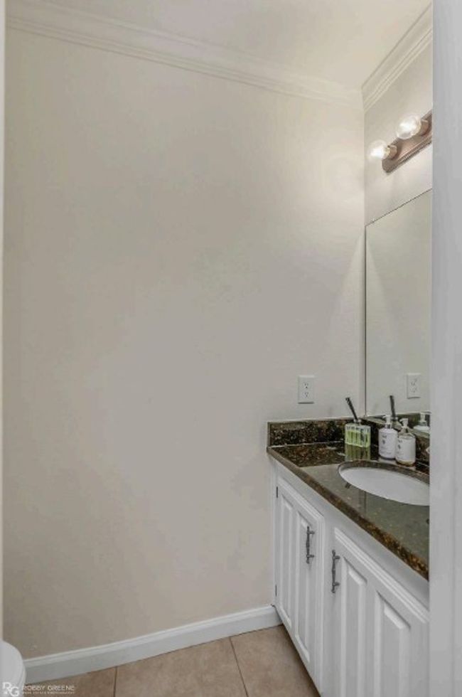 Bathroom with baseboards, tile patterned floors, vanity, and ornamental molding | Image 21