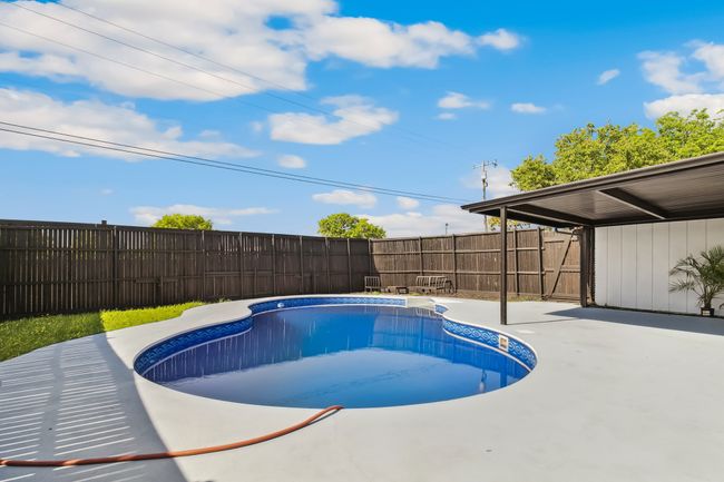 View of swimming pool with a fenced in pool, a fenced backyard, and a patio area | Image 36