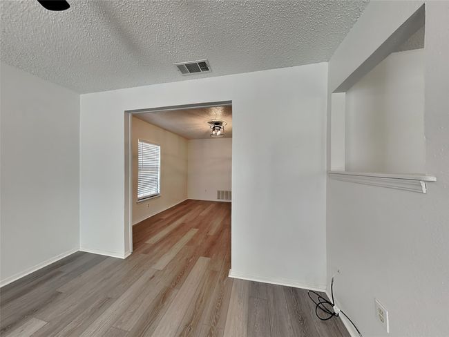 Spare room with wood finished floors, a textured ceiling, and baseboards | Image 10