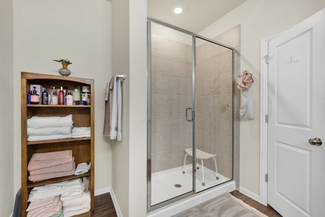 Full bath featuring baseboards, a stall shower, and wood finished floors | Image 18