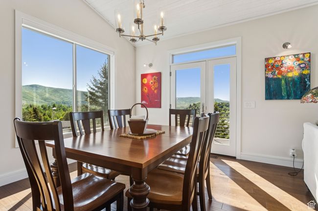 Dining space with a mountain view, wood finished floors, and a chandelier | Image 9