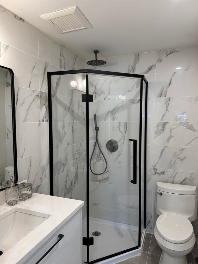 Bathroom with vanity, a shower stall, and tile walls | Image 14
