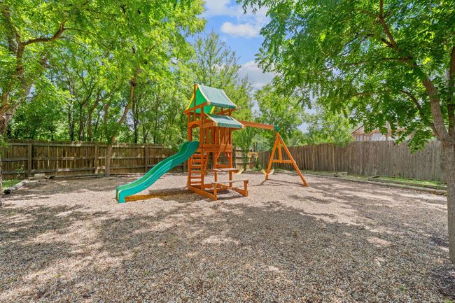 View of jungle gym with a fenced backyard | Image 30