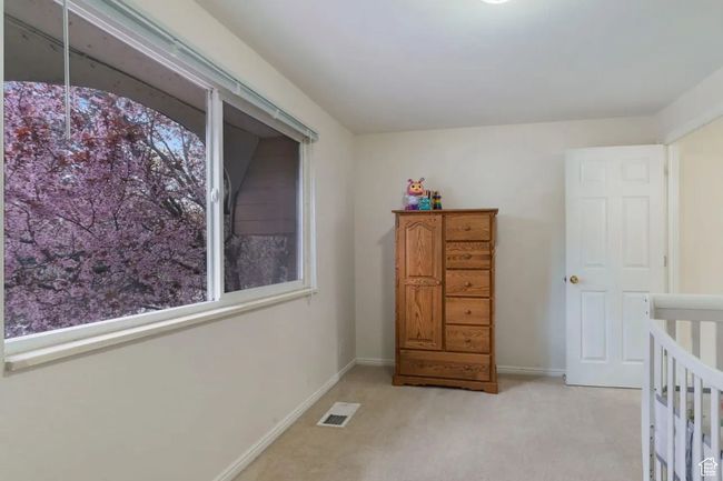 Bedroom with light carpet, visible vents, and baseboards | Image 7