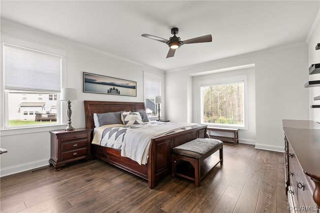 Bedroom with multiple windows, crown molding, dark wood-type flooring, and ceiling fan | Image 22