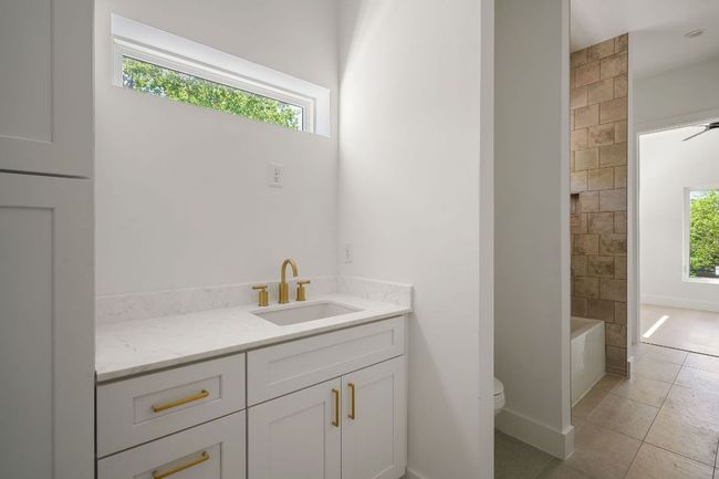 Bathroom featuring vanity, tile patterned flooring, toilet, baseboards, and a bathtub | Image 20