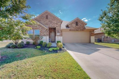 View of front of property featuring cooling unit, a garage, and a front lawn | Image 1