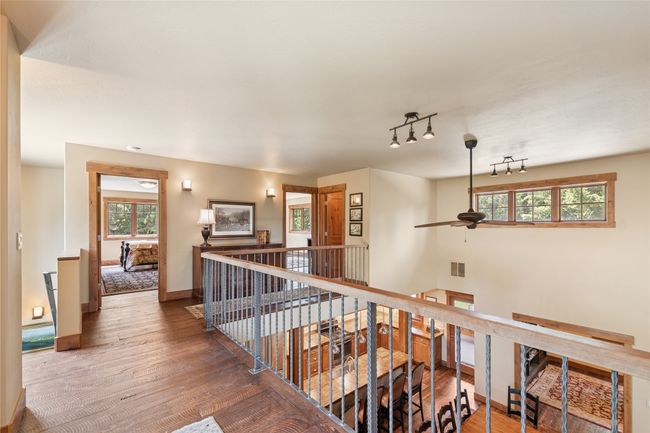 Hall with an upstairs landing, wood finished floors, and rail lighting | Image 40
