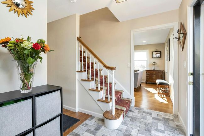 Handsome tile apron in entry, staircase and living room in view. | Image 11