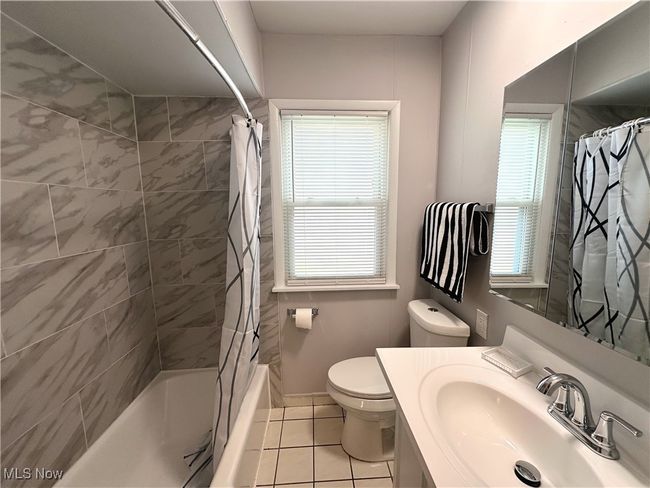Full bathroom with shower / bath combo, toilet, tile patterned flooring, and plenty of natural light | Image 4