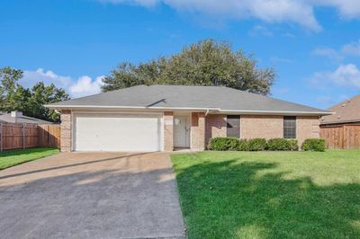 Ranch-style house featuring a front lawn and a garage | Image 1