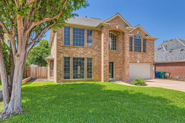 Traditional-style house with driveway, an attached garage, brick siding, and roof with shingles | Image 4