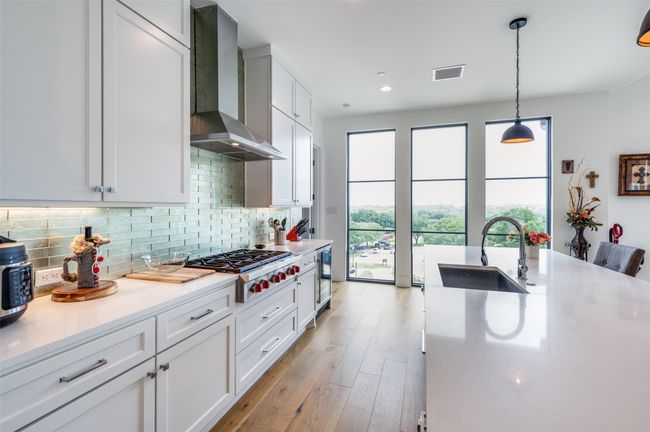 Another view of the kitchen with pretty view from floor to ceiling windows. | Image 11