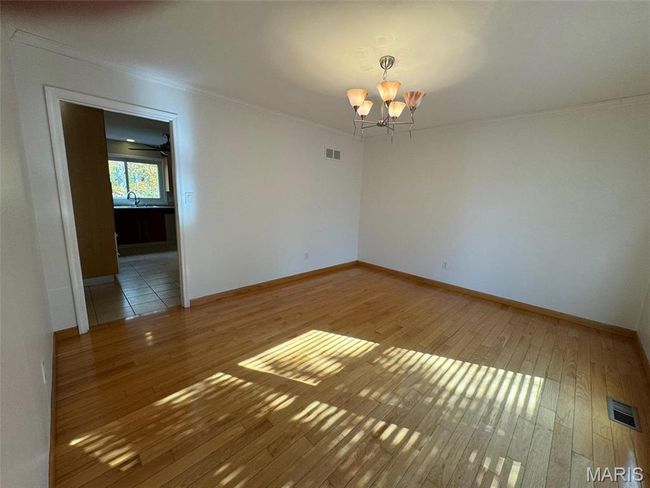 dining room with an inviting chandelier, sink, wood-type flooring, and ornamental molding | Image 13