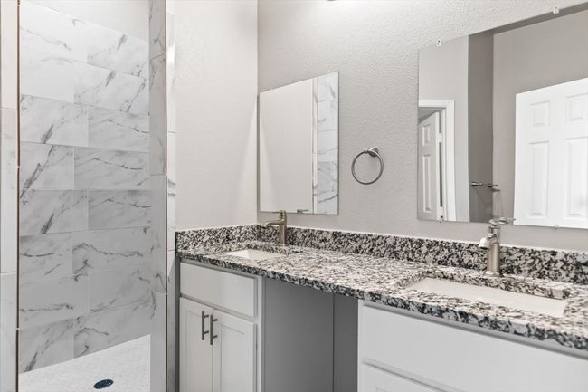Bathroom with a tile shower and vanity | Image 15