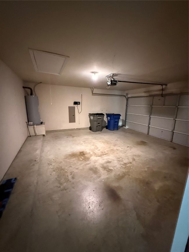 Garage with a garage door opener, electric panel, and water heater | Image 17