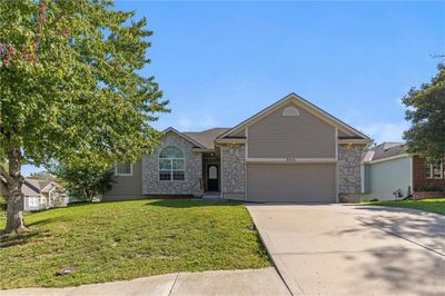 Single story home featuring a front yard and a garage | Image 1