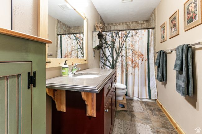 Full bathroom with vanity, stone finish floors, and curtained shower | Image 19