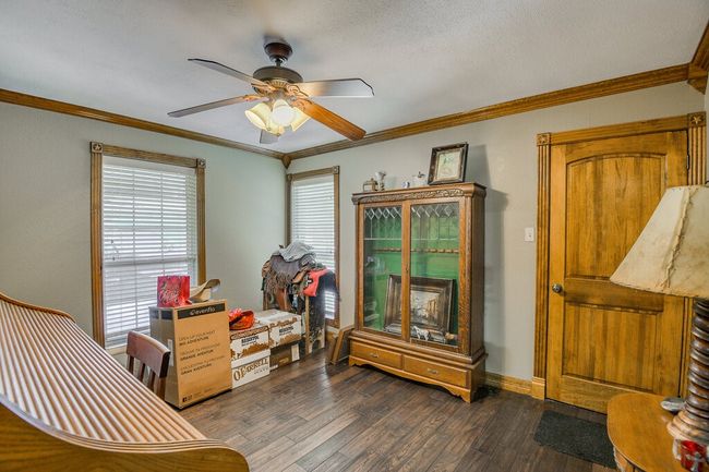 Sitting room with dark wood-style flooring, ceiling fan, and ornamental molding | Image 16